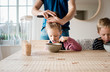 © Cavan Images - father brushing his daughters hair whilst eating breakfast