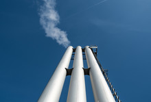 Low Angle View Of Chimneys Against Blue Sky