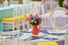 Decorated Party Table Setting With Bird House And Flower Arrangements In Polka Dots Jars