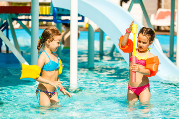 two little kids playing in the swimming pool