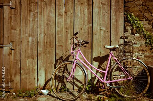 Dekoracja na wymiar  vintage-rozowy-rower-zaparkowany-na-wyblaklym-tle-drewnianej-bramy-kolor-efektu-vintage
