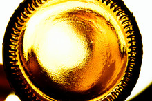 Glass Lemonade Bottle With Contour Lighting. Bottom Of A Glass Beer Bottle Close-up, Background. Screensaver With The Bottom Of A Ale Bottle. Abstract Surface Made Of Brown Plastic With Orange Light. 