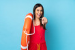Lifeguard woman over isolated blue background with lifeguard equipment and points finger at you