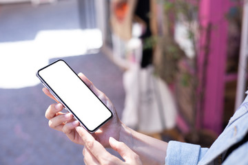 Mockup image blank white screen cell phone.man hand holding texting using mobile on street in city.background empty space for advertise text.people contact marketing business,technology