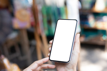 Mockup image blank white screen cell phone.man hand holding texting using mobile at outdoor market.background empty space for advertise text.people contact marketing business,technology