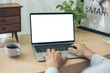 © panitan - mockup image blank screen computer with white background for advertising text,hand man using laptop contact business search information on desk at home office.marketing and creative design