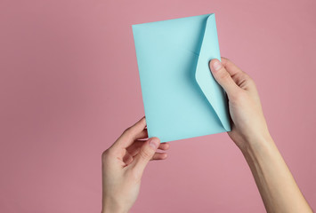 Sticker - Female hand holds envelope with letter on pink pastel background. Top view. Valentine's day, wedding invitation, letter of love