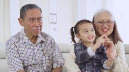 Wall Mural - Girl and grandparents singing together at home