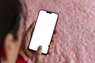 Wall Mural - Close-up of female holding smartphone in bed in room