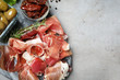 Tasty prosciutto served on light grey table, flat lay. Space for text