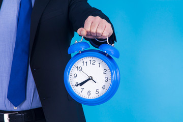 businessman holding alarm clock in his hand