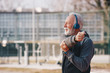 © Sanja - An elderly man stretching his shoulder in an outdoor sports centre.