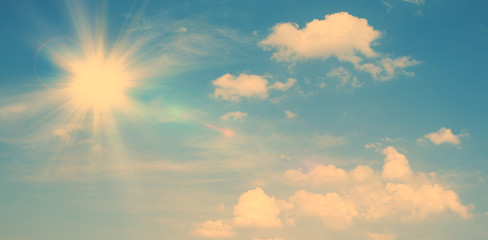Wall Mural - sunny natural background, blue sky with sun and white clouds vintage background.