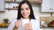 © di_media - Portrait Of Attractive Brunette Female Looking At Camera Holding Cup In Kitchen