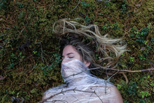 YOUNG WOMAN LYING ON GRASS