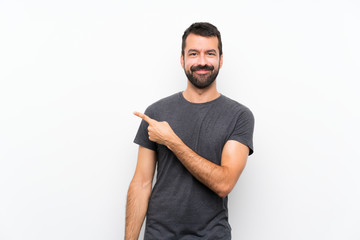 Wall Mural - Young handsome man over isolated white background pointing to the side to present a product