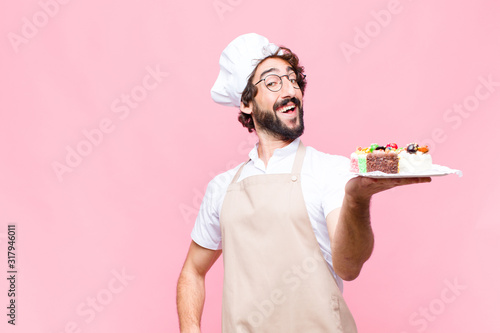 Fotografía young crazy baker man confectionery concept against pink wall