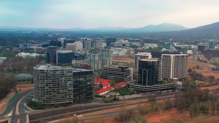 Wall Mural - Panoramic aerial view of Canberra City, the capital of Australia, travelling north toward the Ovolo Nishi building, NewActon South Building and BreakFree Capital Tower on a cloudy early morning 