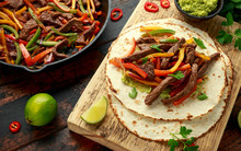 Beef Steak Fajitas With Tortilla Mix Pepper, Onion And Avocado On Wooden Board