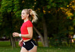 © Ilnur - A young girl goes in for sports outdoors. woman in shorts and red t-shirt runs in nature