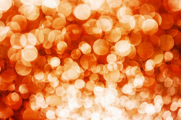 Party festive happy glitter texture. Orange bokeh shiny background. Abstract vibrant color glowing white spots texture for graphic design. Magic colorful backdrop.