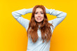 Teenager redhead girl over isolated yellow background frustrated and takes hands on head