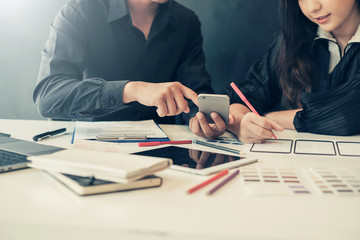 Two young team of ui ux designer planning and analyze applications on mobile phone.