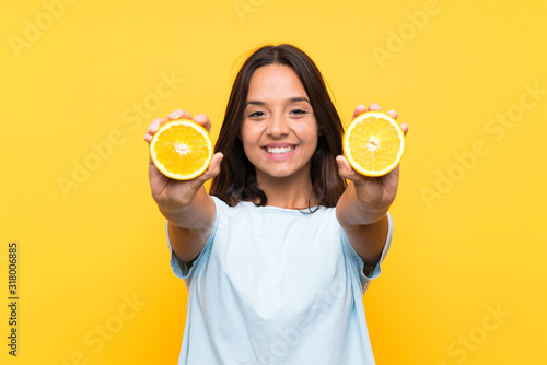 Cuadros en Lienzo Young brunette girl holding an orange