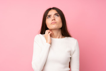 Wall Mural - Young woman over isolated pink background thinking an idea