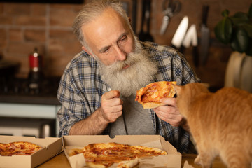 Close-up view of happy bearded senior man eating pizza