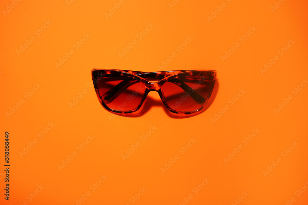 Stylish sunglasses on color background