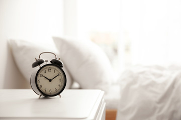 Wall Mural - Black alarm clock on nightstand in morning. Space for text