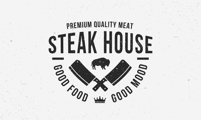 Wall Mural - Steak House vintage logo design. Label for BBQ, Restaurant, Meat store, Butchery. Vintage typography with buffalo and crossed meat cleavers. Vector template.