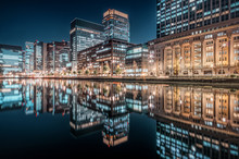 Reflection Of Illuminated Buildings In Lake At Night