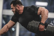 © ruslanshug - strong young bearded caucasian man in black sportswear lifting heavy weight dumbbell with one muscle with vein hand training back and arms in sport gym training routine