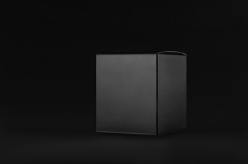 elegant black paper cube box on dark black background, side view, mock up of packing for product, ad