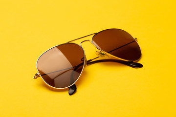 Wall Mural - Sunglasses isolated on yellow background.