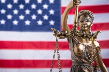 Wall Mural - The statue of justice Themis or Iustitia, the blindfolded goddess of justice against a flag of the United States of America, as a legal concept