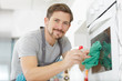 © auremar - a man is cleaning an oven