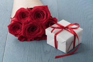 Red roses on wood table with gift box