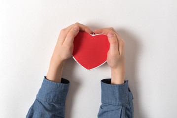 Wall Mural - Small red heart shaped box in male hand isolated on white background