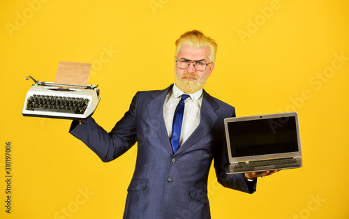 Plakat hard choice. new and old technology. modern digital business. vintage typewriter. successful businessman use retro typewriter and modern laptop. mature man dyed beard hair. computer or typewriter