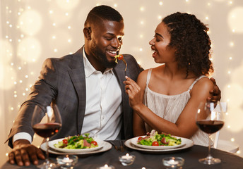 Wall Mural - Young couple feeding each other while spending time at restaurant