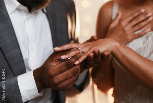 Fotografía Close up of afro man putting ring on woman finger