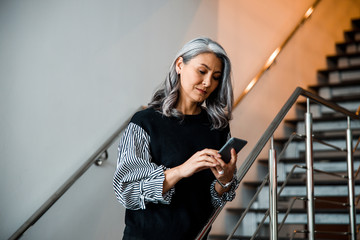 Wall Mural - Calm lady on the stairs with her gadget stock photo