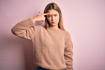 Sticker - Young beautiful blonde woman wearing winter wool sweater over pink isolated background pointing unhappy to pimple on forehead, ugly infection of blackhead. Acne and skin problem