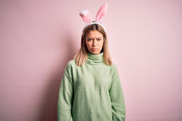 Poster - Young beautiful woman wearing easter rabbit ears standing over isolated pink background depressed and worry for distress, crying angry and afraid. Sad expression.