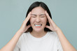 © Varangkana - Exhausted Caucasian woman isolated on blue studio background touch massage temples suffer from strong migraine and fever.
