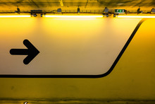Black Arrow Symbol On Illuminated Yellow Wall