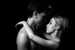 guy and girl are standing in an embrace on a black background, black and white photo
